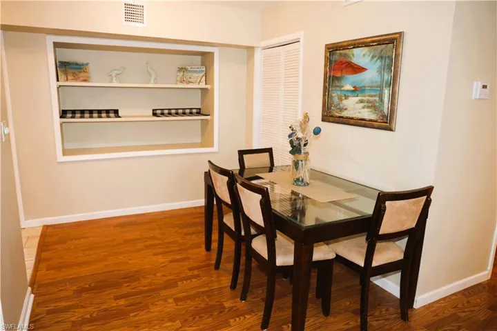 Dining space with wood finished floors and built in shelves