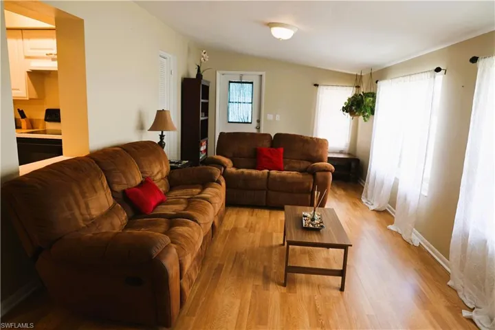 Living room featuring light wood-type flooring and vaulted ceiling