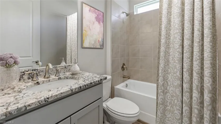 This image is virtually staged. Bathroom with shower / bathtub combination with curtain and vanity