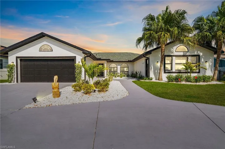 Ranch-style home with concrete driveway, stucco siding, a garage, and a front lawn