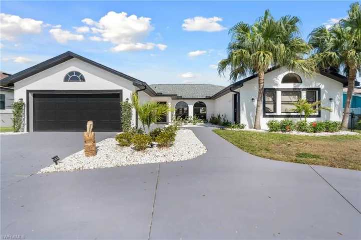 Ranch-style home with a garage, driveway, and stucco siding