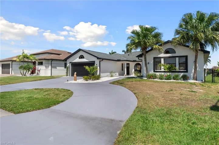 Ranch-style house with stucco siding, curved driveway, a front lawn, a garage, and fence