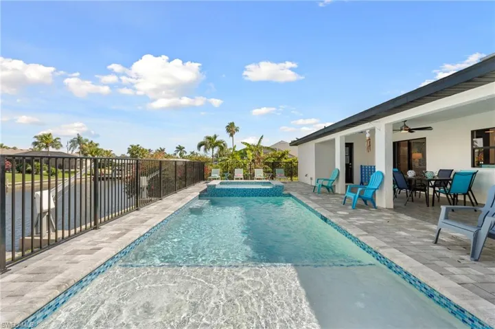 View of swimming pool with a patio area, a pool with connected hot tub, fence, and ceiling fan