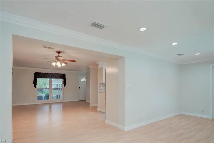 Empty room with crown molding, light wood-style floors, a ceiling fan, and recessed lighting