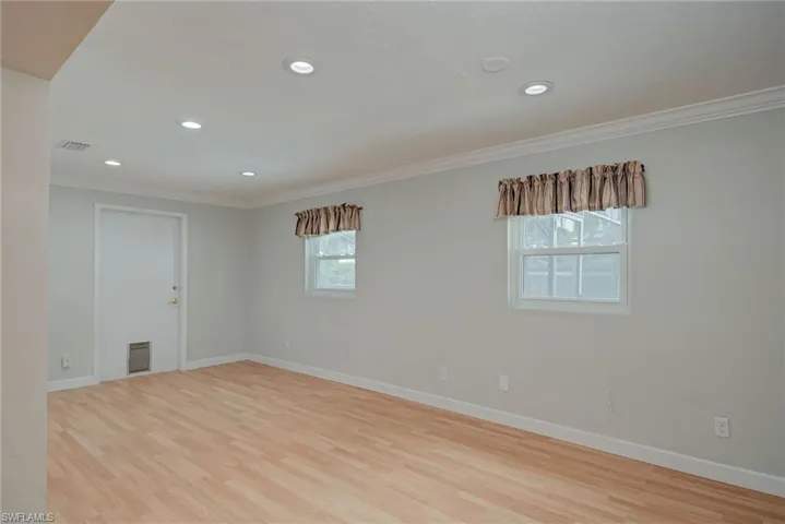 Spare room with ornamental molding, recessed lighting, and light wood-style floors