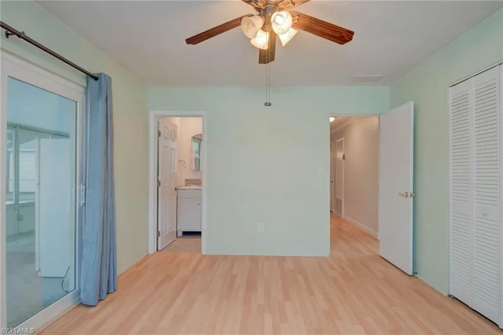 Unfurnished bedroom with a closet, light wood-type flooring, a ceiling fan, ensuite bathroom, and freestanding refrigerator