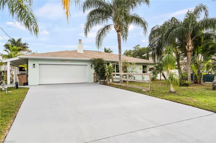 Ranch-style house with a garage and a front lawn