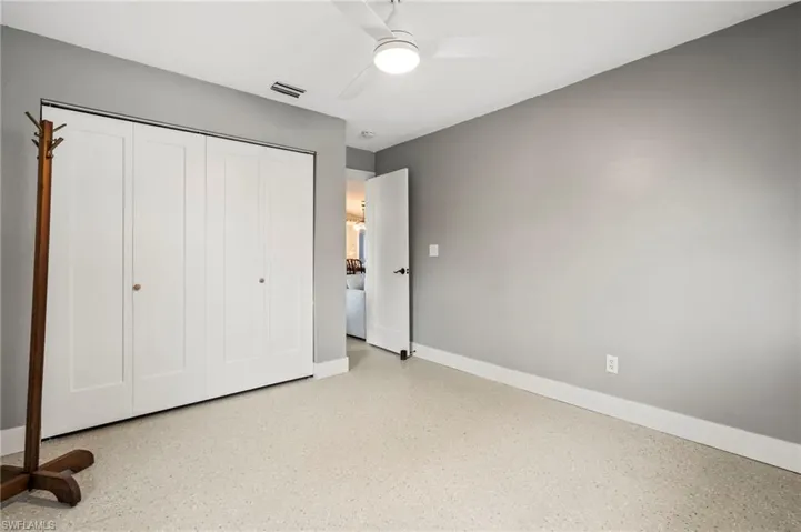 Unfurnished bedroom with ceiling fan and a closet