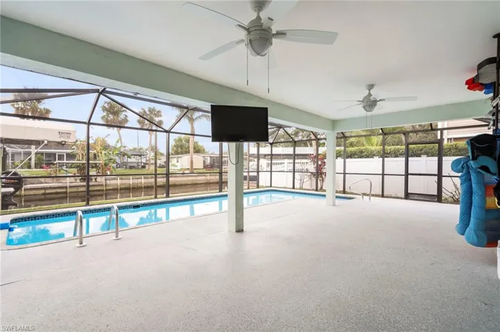 View of pool with ceiling fan, a lanai, and a patio
