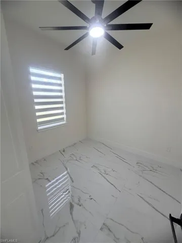 Unfurnished room featuring baseboards and light marble finish flooring