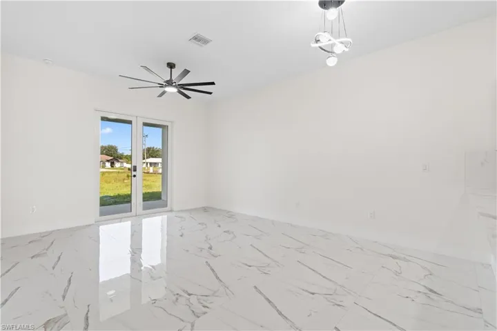 Spare room featuring marble finish floors and french doors