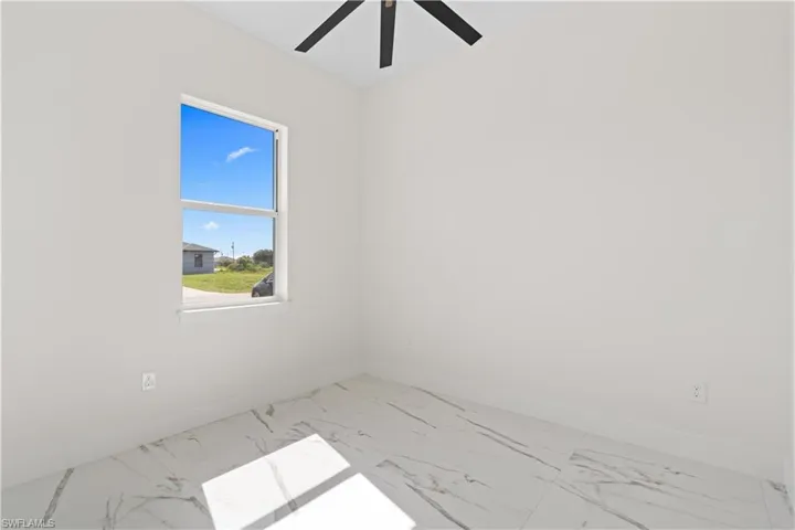 Empty room with marble finish flooring and ceiling fan