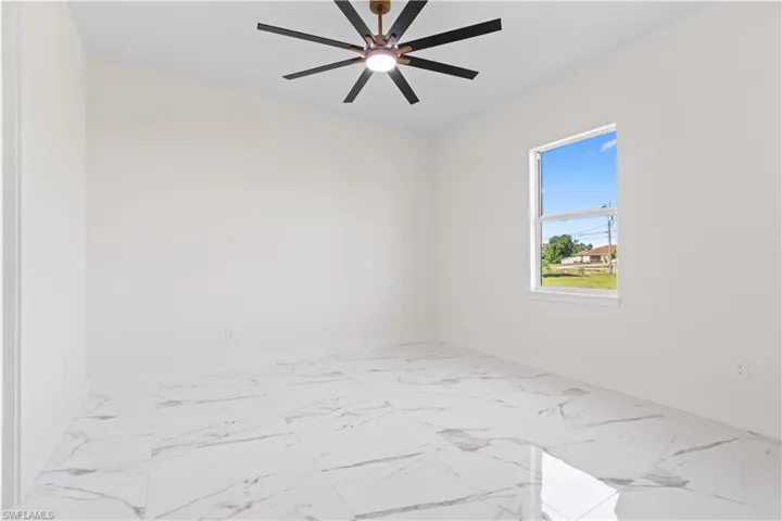 Empty room featuring marble finish flooring and baseboards