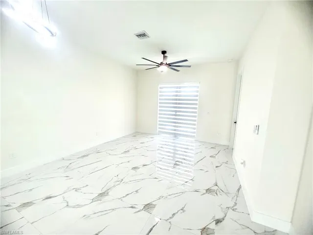 Spare room featuring baseboards and light marble finish flooring