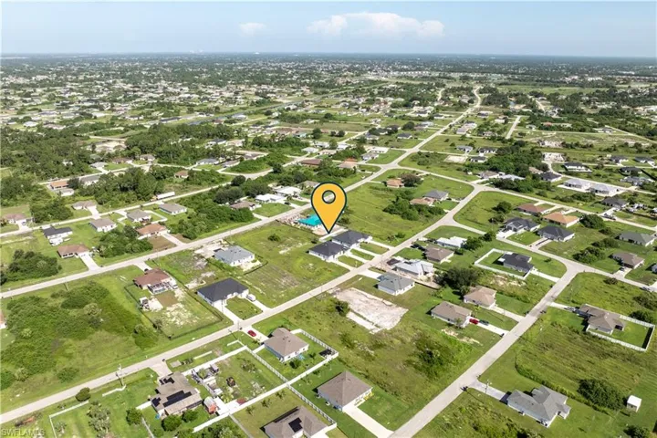 Aerial view of property and surrounding area with nearby suburban area