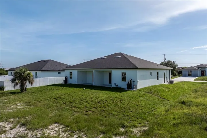 Rear view of property with stucco siding and roof with shingles