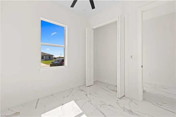 Unfurnished bedroom featuring marble finish flooring and ceiling fan