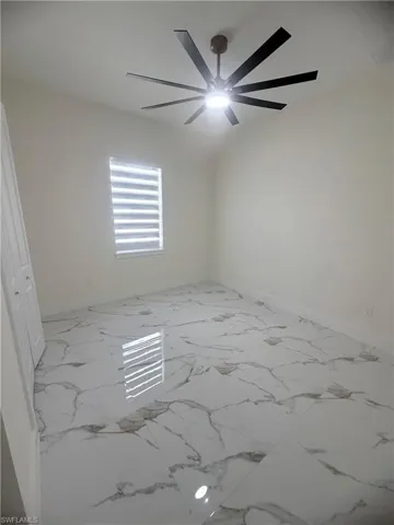 Spare room with light marble finish flooring and baseboards