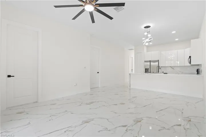 Unfurnished living room featuring light marble finish flooring, recessed lighting, and ceiling fan