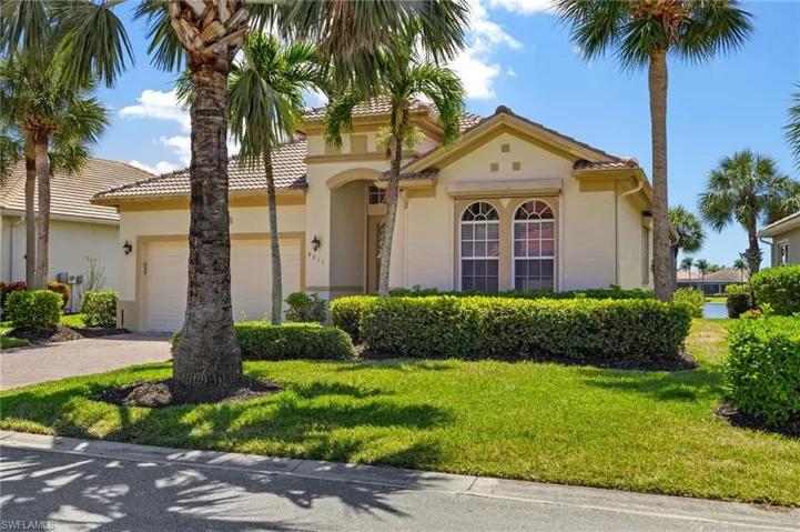 View of front of home with a tiled roof, driveway, an attached garage, a front yard, and stucco siding