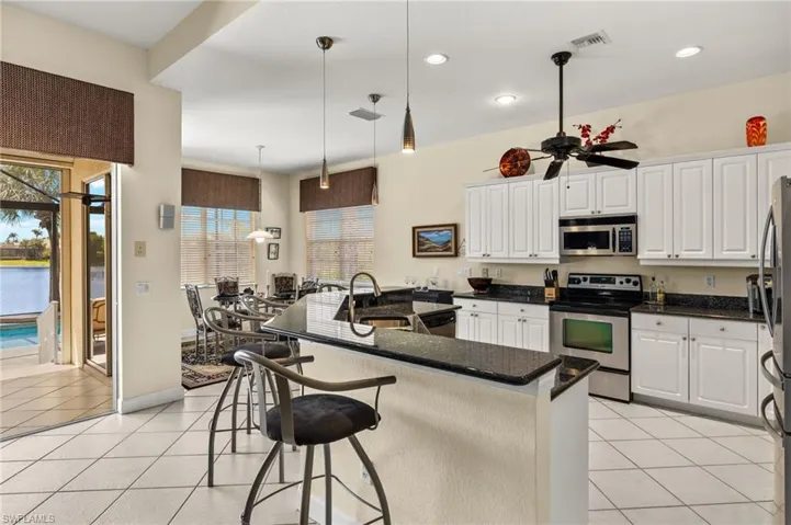 Kitchen with a sink, light tile patterned floors, white cabinetry, appliances with stainless steel finishes, and recessed lighting