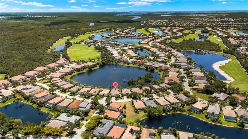 Aerial view featuring golf course view, a water view, and a residential view