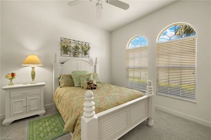 Carpeted bedroom featuring baseboards, a ceiling fan, and lofted ceiling
