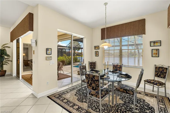 Dining space with light tile patterned flooring and baseboards