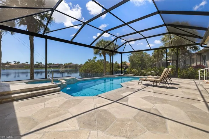 View of swimming pool featuring a water view, a lanai, a pool with connected hot tub, and a patio