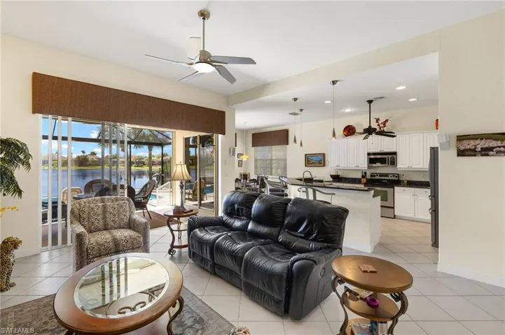 Living room featuring a water view, light tile patterned flooring, baseboards, recessed lighting, and ceiling fan