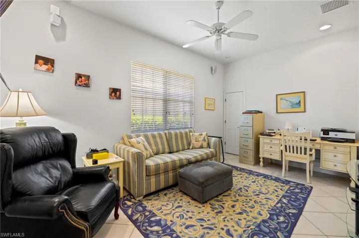 Living area with visible vents, a ceiling fan, and light tile patterned floors