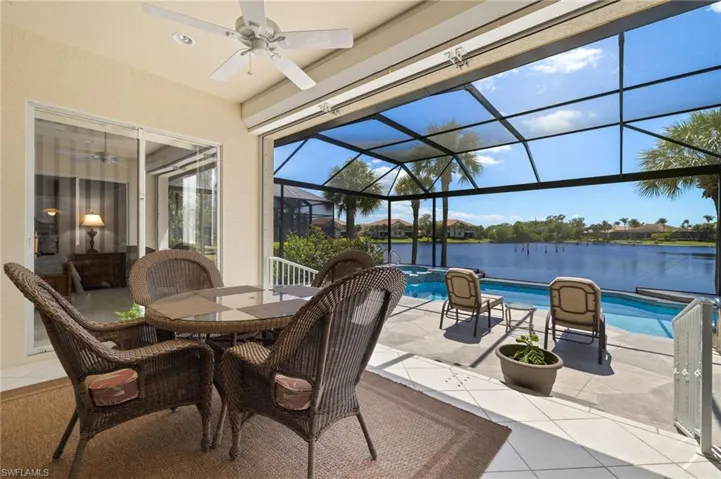 View of patio / terrace featuring a water view, outdoor dining space, a pool with connected hot tub, a lanai, and ceiling fan