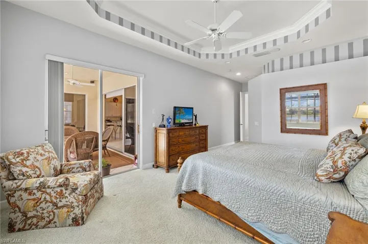 Bedroom with recessed lighting, a tray ceiling, a ceiling fan, baseboards, and carpet flooring