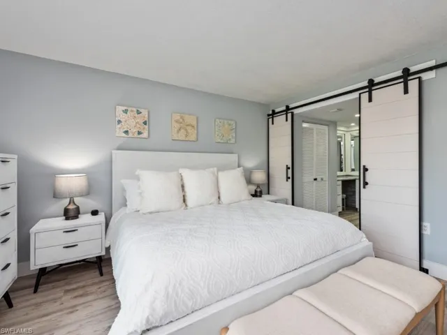 Bedroom with a barn door and wood finished floors