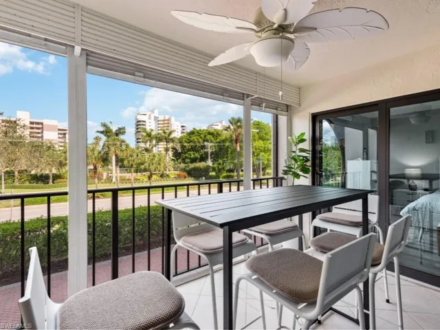 Sunroom with a ceiling fan, outdoor dining space, and tile patterned flooring