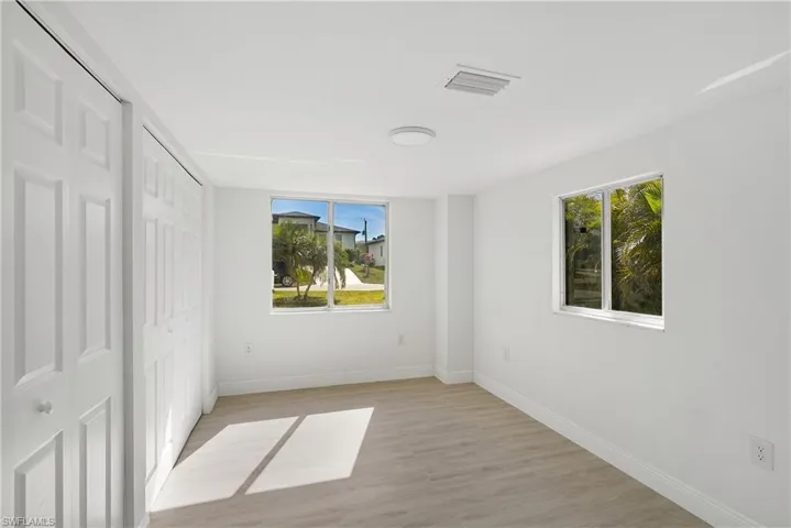 Apartment 1 Unfurnished bedroom with multiple windows and light hardwood / wood-style floors