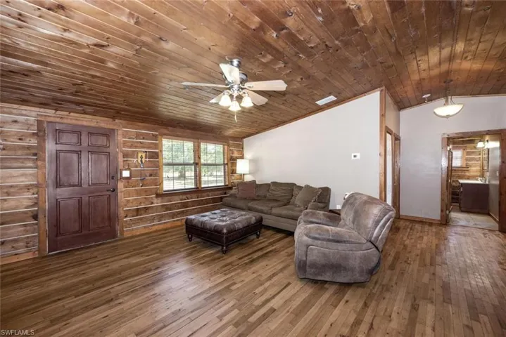 Living area featuring lofted ceiling, hardwood / wood-style flooring, wood ceiling, and visible vents