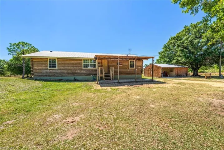 Rear view of house with log siding and a yard