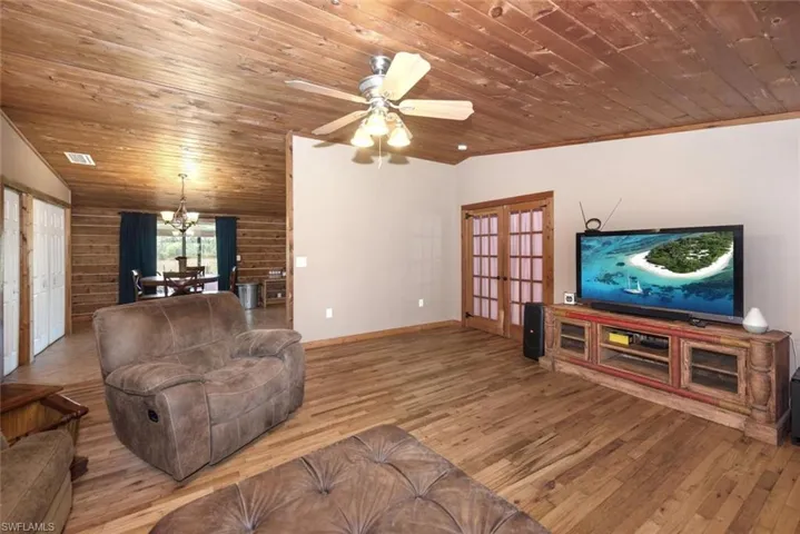 Living room with hardwood / wood-style flooring, french doors, wooden ceiling, and vaulted ceiling