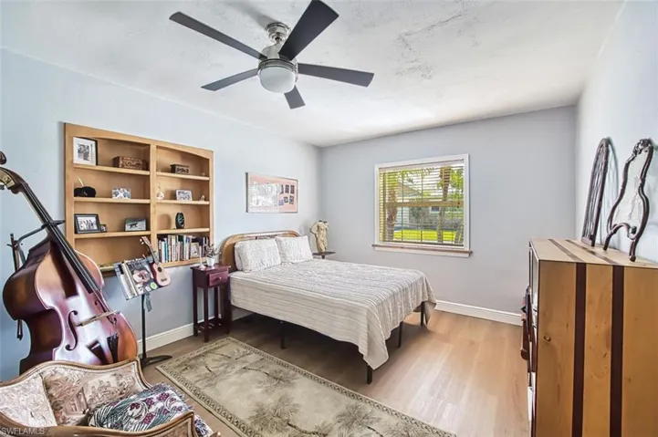 Bedroom with ceiling fan, baseboards, and wood finished floors