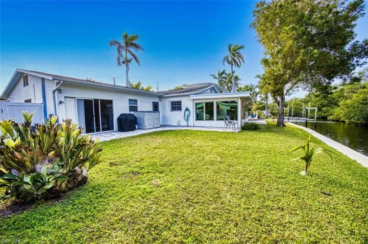 Back of property featuring a patio area, stucco siding, a lawn, and fence