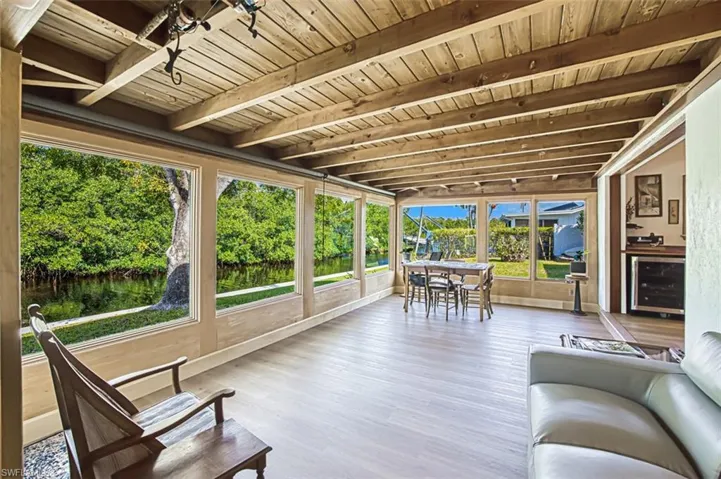 Sunroom featuring beam ceiling, beverage cooler, and wooden ceiling