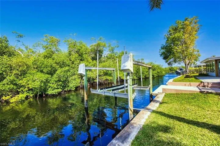 View of dock with a yard, a water view, and boat lift