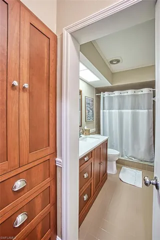 Full bathroom with visible vents, curtained shower, toilet, and vanity