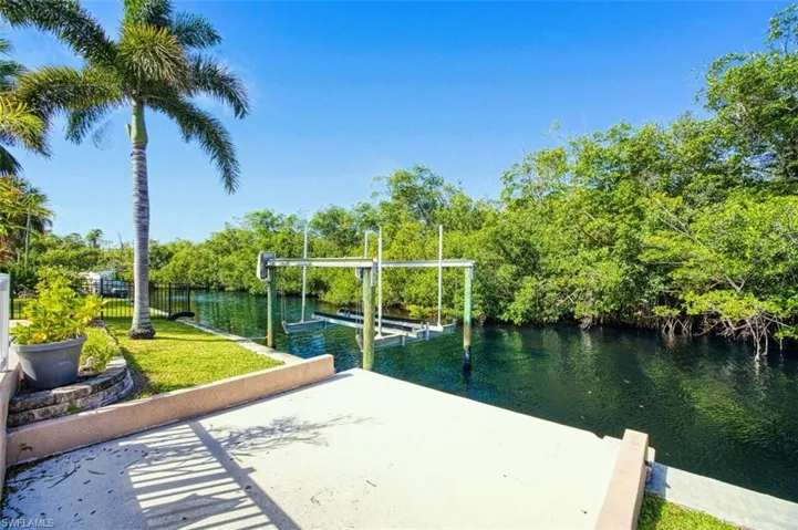 Dock area featuring a lawn, a water view, and boat lift