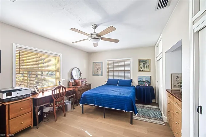 Bedroom featuring a ceiling fan, visible vents, and light wood finished floors