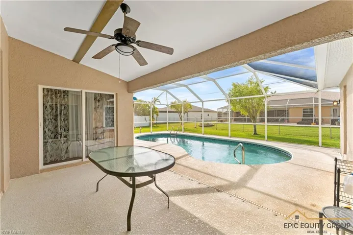 View of pool featuring patio surround, a sunroom, and glass enclosure