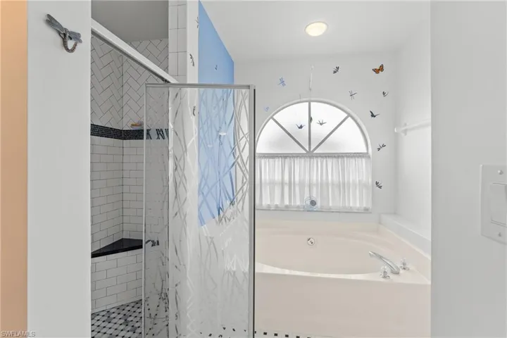Full bath with a shower stall and a bath