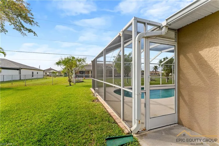 Fenced backyard featuring an outdoor pool, a sunroom, a lanai, and a patio area
