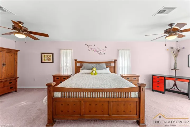 Carpeted bedroom with a ceiling fan
